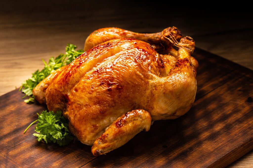 A roasted whole chicken on a cutting board.